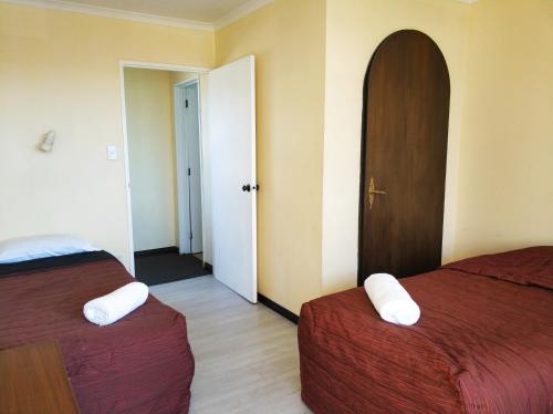a hotel room with two beds and a door at Ferry Motel in Christchurch