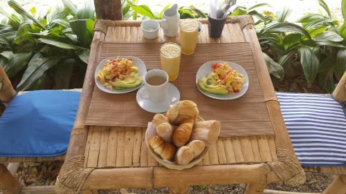 einen Tisch mit Teller mit Essen und Brot darauf in der Unterkunft Villa al Fe in Los Órganos