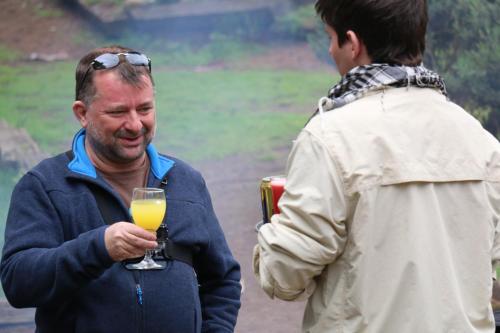 an older man holding a glass of orange juice at Posada del Parque in Concón