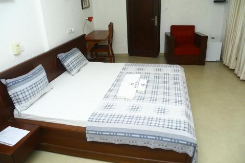 a large bed in a room with a red chair at Amazing Grace Residence in Cotonou