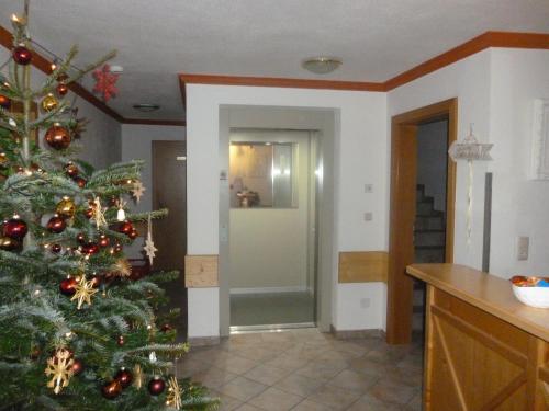 a christmas tree in a room with a kitchen at Hotel-Pension Theresa in Rauris