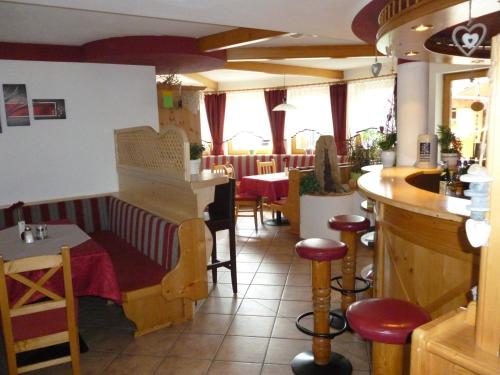 ラウリスにあるHotel-Pension Theresaのバー、テーブルと椅子付きのレストランを提供しています。