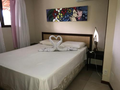 a bedroom with a bed with two swans on it at Pipa Flat Solar in Pipa
