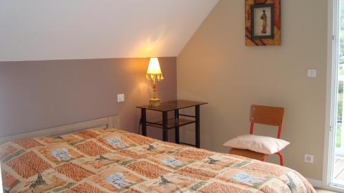 a bedroom with a bed and a table and a chair at Les coquelicots in Luz-Saint-Sauveur