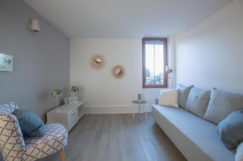 a living room with a couch and a window at 1834&Spa Colmar in Colmar