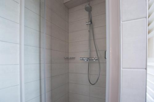 a shower with a shower head in a bathroom at 1834&Spa Colmar in Colmar