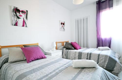 1 dormitorio con 2 camas y una pintura de una mujer en Modern Apartment in Valencia, en Valencia