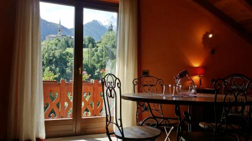 a table and chairs in a room with a window at Il Rifugio della Volpe in Introd