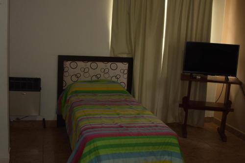 1 dormitorio con 1 cama y TV de pantalla plana en Apartamento Los Abuelos Calle Esteva Berga en Colón