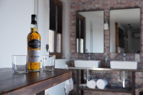 a bottle of beer sitting on a counter with glasses at 1834&Spa Colmar in Colmar