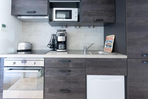 a kitchen with a sink and a microwave at 1834&Spa Colmar in Colmar