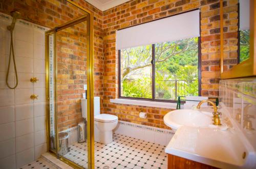 a bathroom with a toilet and a sink and a window at Aquila in Mount View