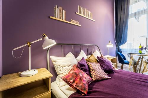 ブダペストにあるThe purple - studio apartment in the centre of Budapestの紫の壁のベッドルーム1室、ベッド1台(枕付)