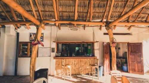 a building with a restaurant with a straw roof at Badaboom Hostal & Surf in Aposentillo