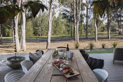 a wooden table with a plate of food on it at Dogwood in Pokolbin