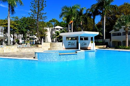 a pool at a resort with blue water at Tropical Casa Laguna in Cabarete