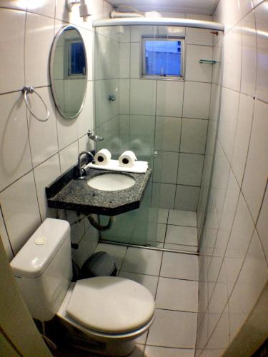 a bathroom with a toilet and a sink and a mirror at Raio de Sol Praia Hotel in Fortaleza