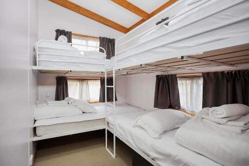 two bunk beds in a white room with windows at Portland Tourist Park in Portland