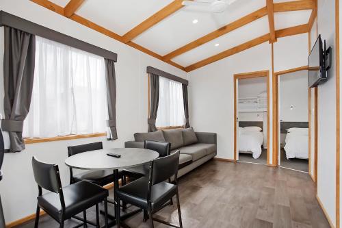a living room with a table and chairs and a couch at Warrnambool Holiday Village in Warrnambool