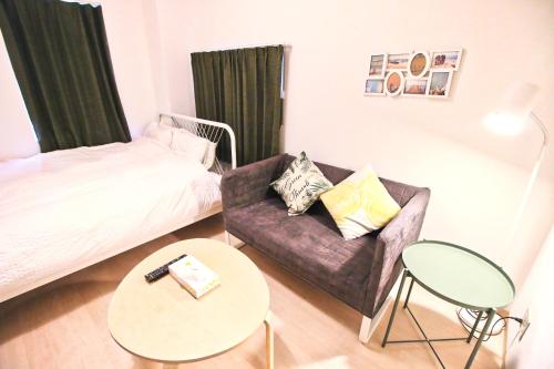 une chambre avec un lit, un canapé et une table dans l'établissement Uhome Kanda Hotel, à Tokyo
