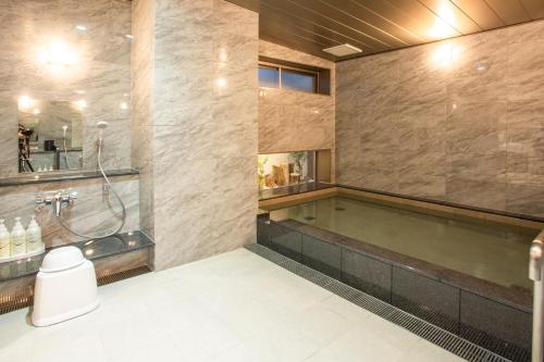 a large bathroom with a swimming pool and a tub at Kuretake Inn Osaka Midousuji Hommachi in Osaka