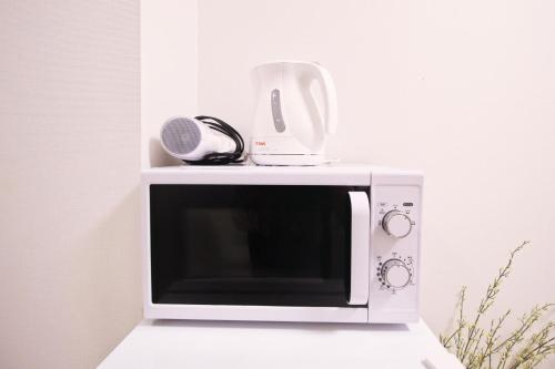 a microwave with a blender on top of it at Uhome Kanda Hotel in Tokyo