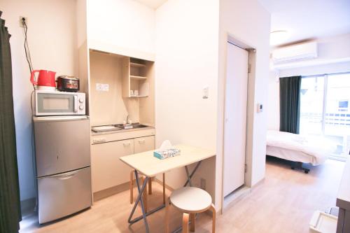 a small kitchen with a small table and a refrigerator at Uhome Kanda Hotel in Tokyo