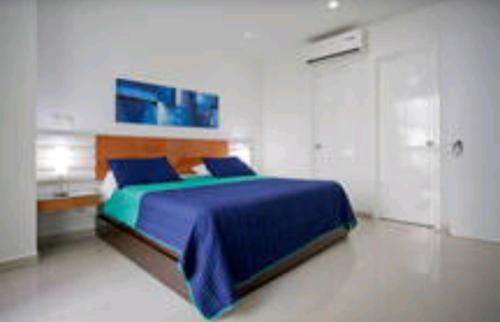 a bedroom with a bed with a blue comforter at Morros Epic Cartagena in Cartagena de Indias