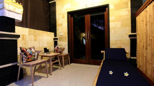a room with a bed and a table and a door at Ayye Bungalows in Ubud
