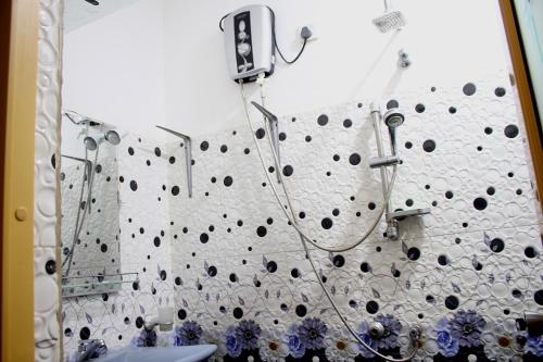 a shower in a bathroom with a wall covered in holes at Mount Valley Rest in Ella