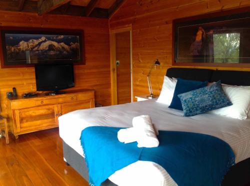 a bedroom with a large bed and a television at Milbrodale Lodge in Broke