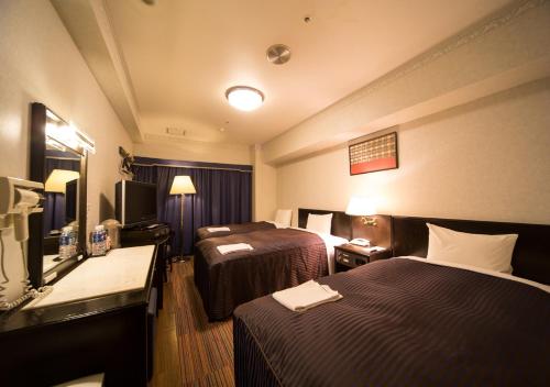 En eller flere senge i et værelse på Hotel Claiton Esaka