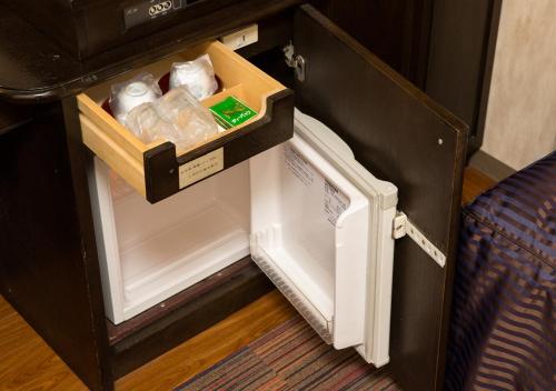 a small refrigerator with its door open with drinks in it at Hotel Claiton Esaka in Suita