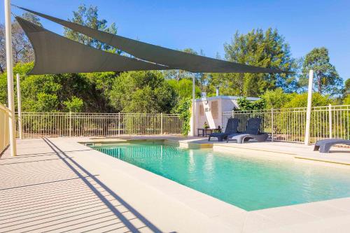 a canopy over a swimming pool in a yard at Monkey Place Country House in Broke