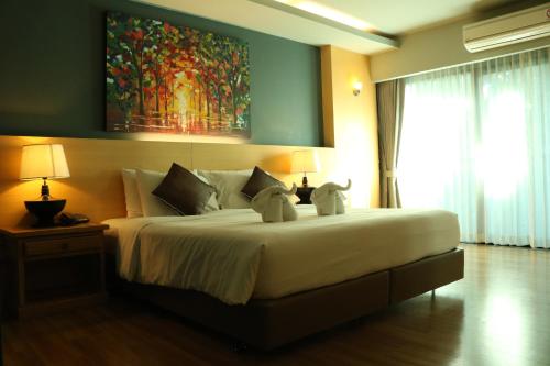 a bedroom with a large bed with two stuffed animals on it at Le Naview @Prasingh in Chiang Mai