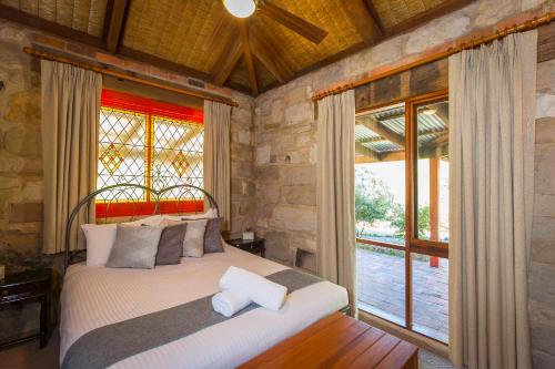 a bedroom with a bed and a large window at Monkey Place Country House in Broke