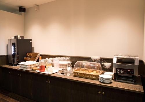 a kitchen with a counter with food on it at Hotel Claiton Esaka in Suita