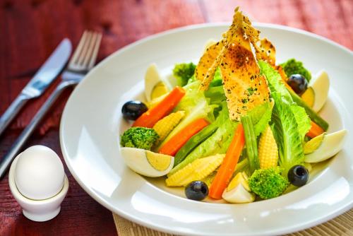 a white plate of food with vegetables on a table at ibis Pune Hinjewadi - An Accor Brand in Pune