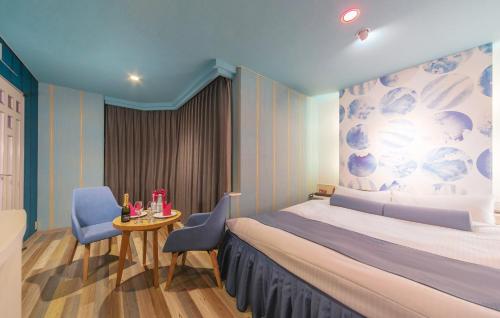 名取市Grand Hotel Staymore -Adult Only的一间卧室，配有一张床、一张桌子和几把椅子