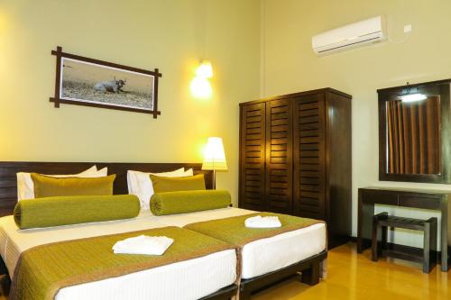 a bedroom with a large bed and a fireplace at Oak Ray Wild Yala in Tissamaharama