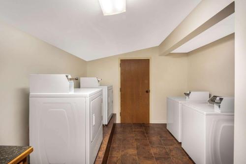 a laundry room with white washers and a wooden door at THE BRANSINN Entertainment District in Branson
