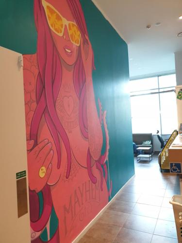 a large painting of a woman with pink hair and sunglasses at Metro Adventurer Backpackers in Auckland