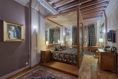 a bedroom with a canopy bed and a desk at Hotel Wentzl in Kraków