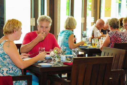a group of people sitting at tables in a restaurant at Oak Ray Wild Yala in Tissamaharama