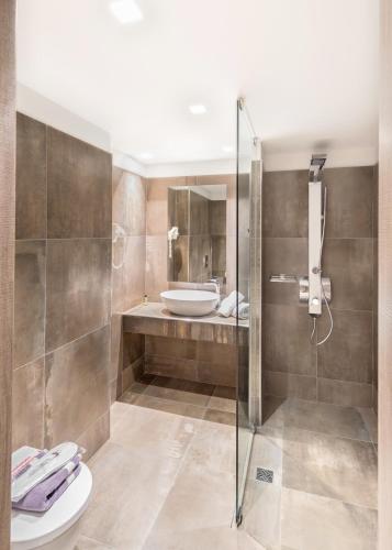 a bathroom with a shower and a toilet and a sink at Castello Hotel in Rio