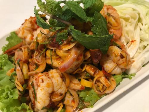 a plate of food with shrimp and lettuce at Grand Business Inn in Bangkok