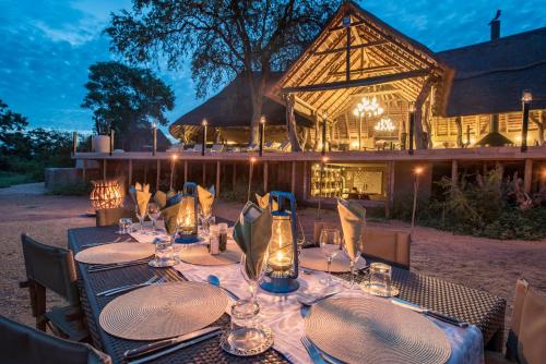 a table set up for a meal in front of a building at Kambaku River Sands in Timbavati Game Reserve