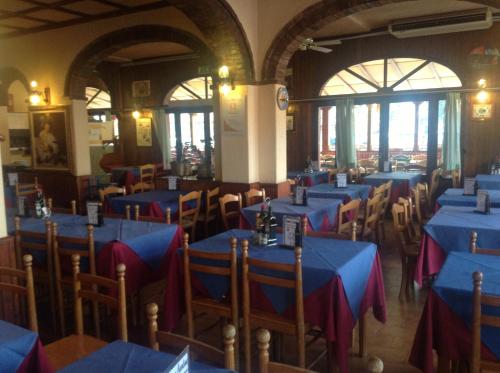 a dining room with blue tables and chairs at Alloggi Taverna Caorlina in Caorle