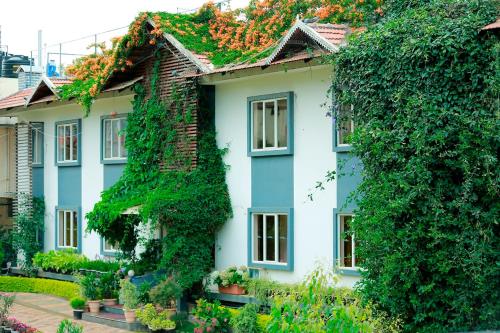 a white house covered in ivy at Sunvalley Homestay in Coonoor