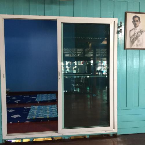 a sliding glass door in a room with a picture at Rub Lom Chom Klong Homestay in Chumphon